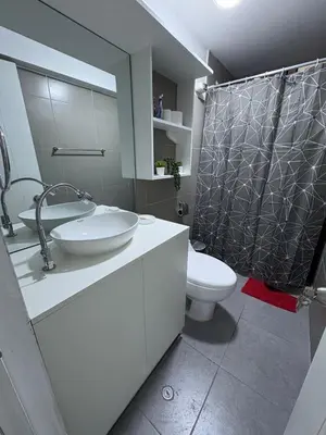 a bathroom with a sink and a shower with a toilet at Mini Departamento in Lima
