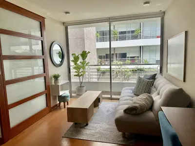 a living room with a couch and a large window at Departamento Athelier in Lima