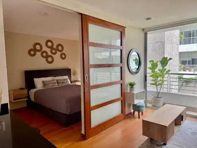 a bedroom with a bed and a sliding glass door at Departamento Athelier in Lima