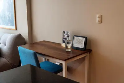 a small table with a tv and a blue chair at Departamento Athelier in Lima