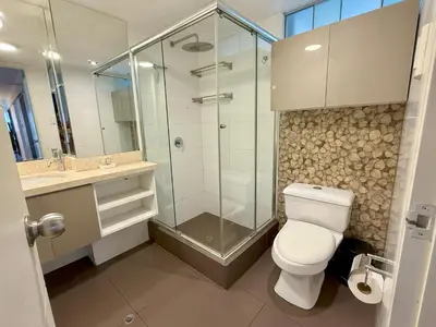 a bathroom with a toilet and a glass shower at Departamento Ricardo Palma in Lima