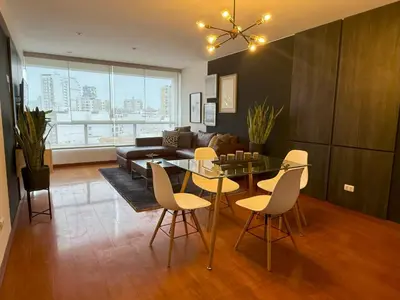 a living room with a glass table and chairs at Departamento Ricardo Palma in Lima
