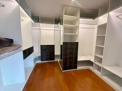 a walk in closet with white cabinets and wood floors at Departamento Ricardo Palma in Lima