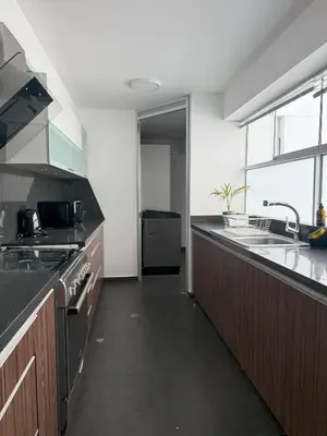a kitchen with black counter tops and a sink at Departamento Ricardo Palma in Lima