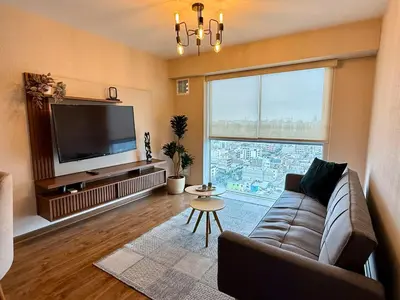 a living room with a couch and a large window at Departamento Lock in Lima