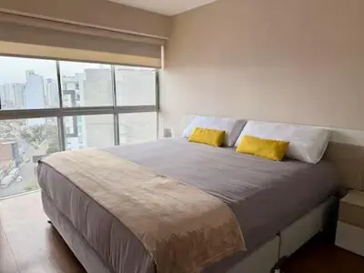 a bedroom with a large bed with two yellow pillows at Departamento Lock in Lima