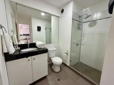 a bathroom with a toilet and a glass shower at Departamento Lock in Lima
