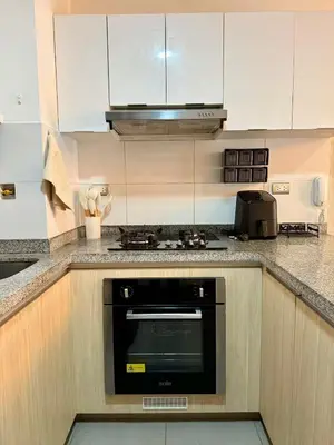 a kitchen with white cabinets and a black oven at Departamento Lock in Lima