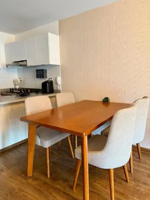 a dining room table with chairs and a kitchen at Departamento Lock in Lima