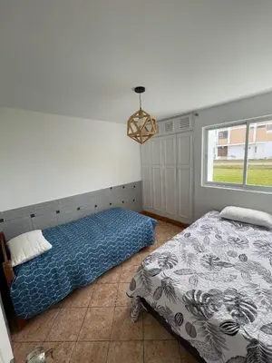 a bedroom with two beds and a window at Casa con Piscina privada y a pasos de la playa in Lurín