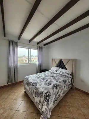 a bedroom with a bed and a large window at Casa con Piscina privada y a pasos de la playa in Lurín