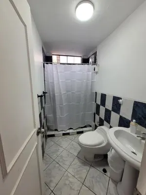 a bathroom with a toilet and a sink at Casa con Piscina privada y a pasos de la playa in Lurín