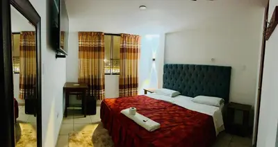 a bedroom with a large bed with a blue headboard at Hotel World Peru in Lima