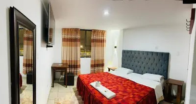 a bedroom with a large bed with a red blanket at Hotel World Peru in Lima