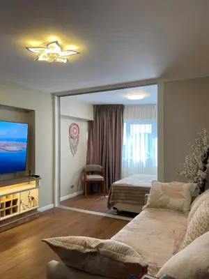 a living room with a couch and a bed and a television at Mini Apartment Ares 2 in Lima