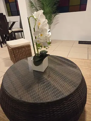 a round table with a vase with white flowers on it at tiki house in Lima