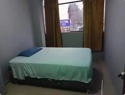 a bed in a room with a window at Departamento minimalista in Lima
