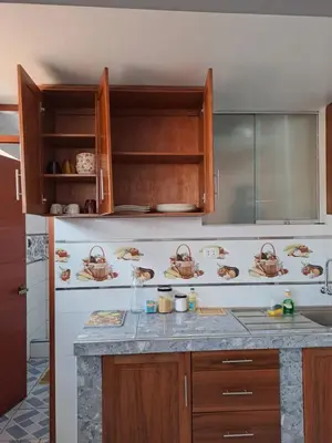 a kitchen with wooden cabinets and a counter top at Nina's House in Cusco