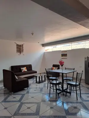 a living room with a table and chairs and a couch at Nina's House in Cusco