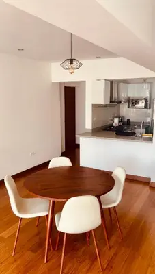 a dining room table with white chairs and a kitchen at Luxloft in Lima