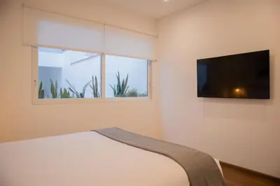 a bedroom with a bed and a flat screen tv at Seaside Apartment near Malecon Miraflores by Wynwood House in Lima