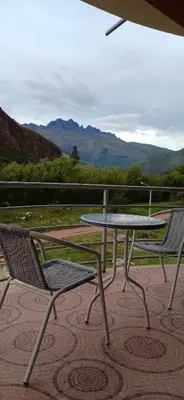 a picnic table and two chairs on a patio at Habitación simple triple in Huayllabamba