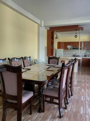 a dining room with a wooden table and chairs at Habitación simple triple in Huayllabamba