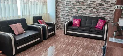 a waiting room with two black couches and pink pillows at Habitación matrimonial con jacuzzi in Huayllabamba