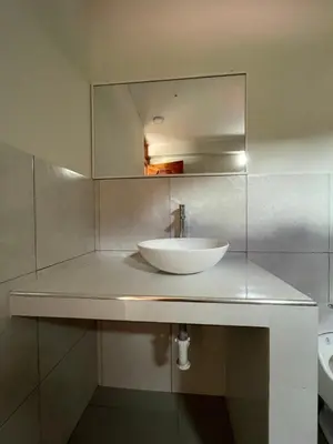 a bathroom with a white sink and a mirror at Habitación matrimonial con jacuzzi in Huayllabamba