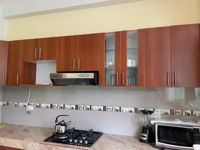 a kitchen with wooden cabinets and a counter top at Habitación matrimonial con jacuzzi in Huayllabamba