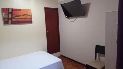 a room with a bed and a flat screen tv at Hospedaje el señorial in Lima