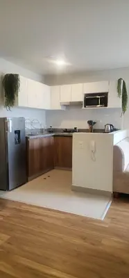 a kitchen with a refrigerator and a counter top at Depa UMBRA, one block from Rebagliati Hospital in Lima