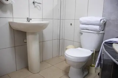 a white bathroom with a sink and a toilet at Los Chullos in Cusco