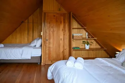 a room with two beds in a wooden cabin at Montecatini Ecolodge in Oxapampa