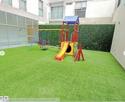 a playground with a slide on the grass at Lovely apartment in front of malecon! in Lima