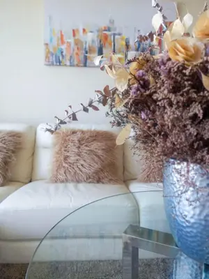 a vase of flowers on a glass table next to a couch at Lovely apartment in front of malecon! in Lima