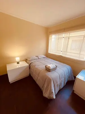 a bedroom with a large bed and a window at Céntrico Dpto Puca Lima a 2 cuadras de Hospital Rebagliati y Real Plaza Salaverry in Lima
