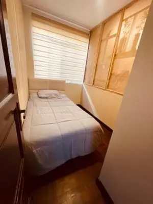a small bed in a room with a window at Céntrico Dpto Puca Lima a 2 cuadras de Hospital Rebagliati y Real Plaza Salaverry in Lima