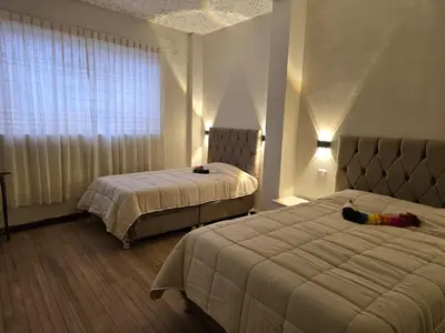 a hotel room with two beds and a window at Mica&Tory in Cusco