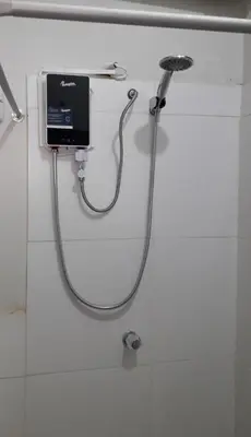 a shower with a hose attached to a wall at Mica&Tory in Cusco