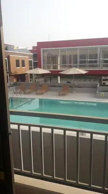 a swimming pool with tables and umbrellas in a building at Lascondes in Chosica