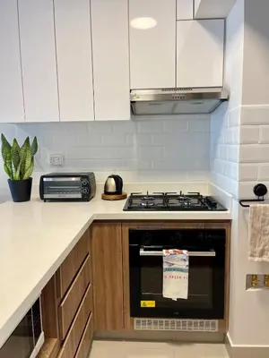 a kitchen with white cabinets and a stove at Calm and Cozy Flat in San Borja in Lima