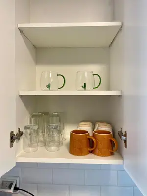 a kitchen shelf with cups and mugs on it at Calm and Cozy Flat in San Borja in Lima