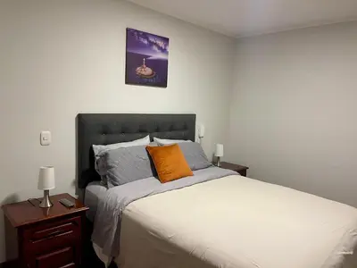 a bedroom with a bed with an orange pillow on it at Calm and Cozy Flat in San Borja in Lima