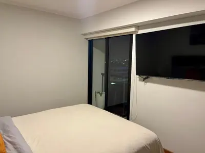 a bedroom with a bed and a large window at Calm and Cozy Flat in San Borja in Lima