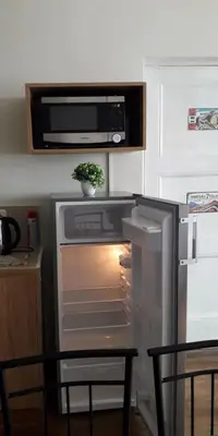 a kitchen with an open refrigerator with a plant in it at Cozy loft in the heart of the city in Cusco