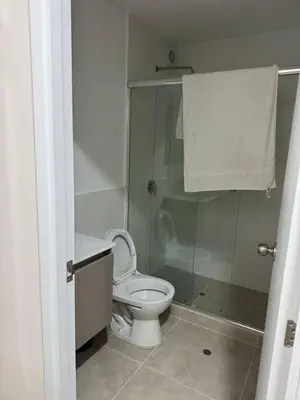 a bathroom with a toilet and a glass shower at 2-Bedroom Apt, Perfect for Family or Work Stays in Lima
