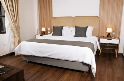 a hotel room with a large bed with white sheets at Barón de Huaura Hotel Boutique in Huaura