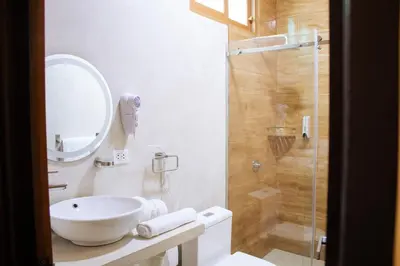 a white bathroom with a sink and a shower at Barón de Huaura Hotel Boutique in Huaura