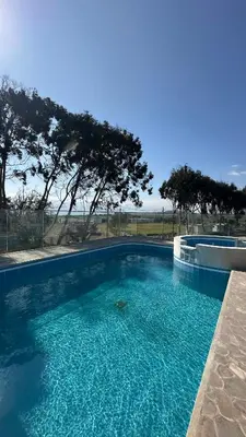a large swimming pool with blue water and trees at Barón de Huaura Hotel Boutique in Huaura